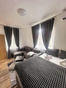 - un salon avec un lit et un canapé dans l'établissement Apartmani M.&.B Luks 2, à Mataruška Banja