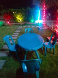 een blauwe tafel en stoelen in een tuin 's nachts bij OYO Durga Palace in Sāngli
