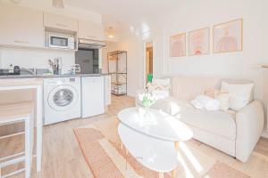 uma sala de estar com um sofá branco e uma cozinha em *Disneyland-Paris* Studio, 2pers, Parking, Wifi em Serris