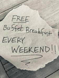 ein Stück Papier mit den Worten "kostenloses Frühstück am Wochenende" in der Unterkunft Windcrest Inn and Suites in Fredericksburg