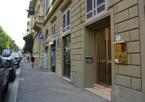 una persona che cammina lungo una strada accanto a un edificio di Alfieri9 a Firenze