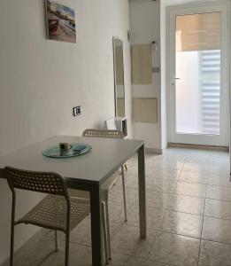 - une salle à manger avec une table et deux chaises dans l'établissement Nonno Tommy, à Polignano a Mare