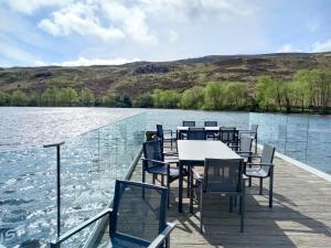 a table and chairs on a dock on a lake at Number 57 Brynteg in Caernarfon