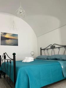 - une chambre avec un lit noir et une couverture bleue dans l'établissement Nonno Tommy, à Polignano a Mare