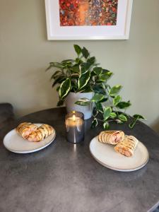 three plates of pastries on a table with a candle at Guildhall - Beauluxe Properties large property - 3 bedroom - 4 beds - sleeps upto 6 people in Church Gresley