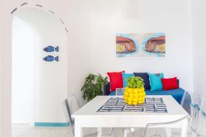 a dining room with a white table and a blue couch at YourHome - Adoro Positano in Positano