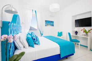 a blue and white bedroom with a bed and a desk at YourHome - Adoro Positano in Positano