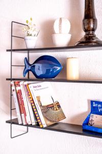 ein Regal mit Büchern und einer blauen Maus und einem Buch in der Unterkunft Coeur de Charente Maritime, venez respirez. in Saint-Germain-de-Marencennes