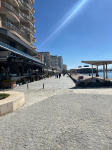 een geplaveide stoep naast een strand met gebouwen bij Sea View Apartaments in Durrës