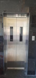 Un gran ascensor metálico con tres letreros. en Kuber Residency, en Tirupati