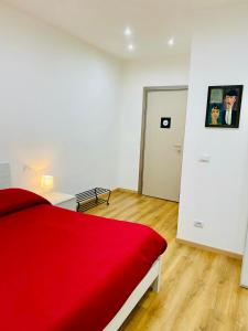 um quarto branco com uma cama vermelha e uma porta em Aria di Casa Experience em Cassino