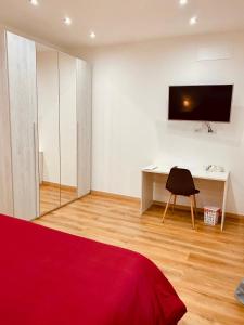 1 dormitorio con escritorio y TV en la pared en Aria di Casa Experience, en Cassino