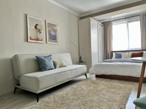 a bedroom with a couch and a bed and a window at Студия ОАЗИС с видом на Коктобе in Almaty