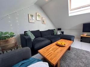 a living room with a blue couch and a wooden table at Le Havre Sanvic - appartement chaleureux in Le Havre