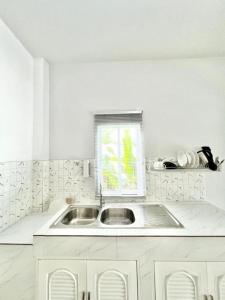 a white kitchen with a sink and a window at Lay Back Villa C2 with Kitchen & High speed Internet in Krabi +12 photos
