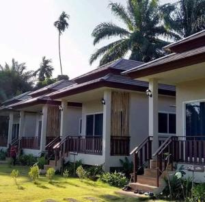 a house with a palm tree in front of it at Lay Back Villa C2 with Kitchen & High speed Internet in Krabi