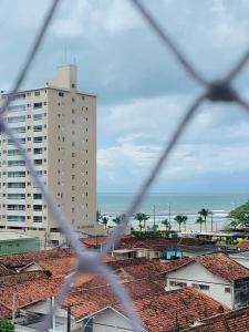 a view of a city from behind a chain link fence at Lindo apto piscina liberada e próximo à praia QX01H in Solemar