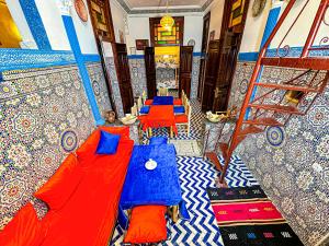 Habitación con 2 mesas de color azul y rojo en Hostel Speakeasy Fes, en Fez