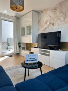a living room with a blue couch and a table at Apartman “Manhattan” in Križevci