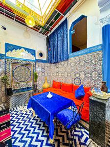 sala de estar con sofá rojo y mesa azul en Hostel Speakeasy Fes, en Fez