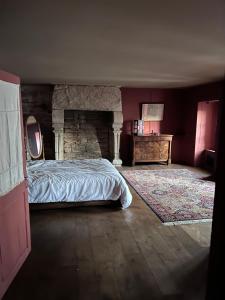 1 dormitorio con cama y pared de piedra en Chambres d’hôtes en centre-ville, en Audierne