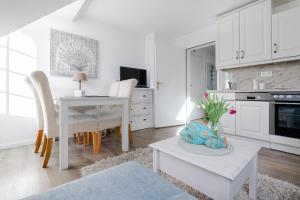 a white living room with a table and a kitchen at Lister Wind in List