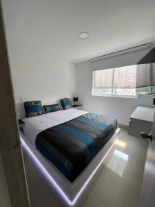 um quarto com uma cama grande e uma luz. em Luxor apartamentos em Medellín