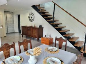 une salle à manger avec une table et un escalier dans l'établissement Maison terre et bord de mer, à Lessay