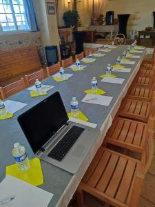 una mesa larga con un portátil encima en Résidence L'Ogomé, en Le Boupère