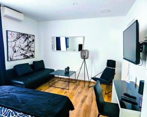 a room with a bed and a couch and a tv at Octagon Main Square Apartment in Zagreb