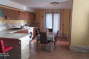 a kitchen with a table and a dining room at Open Space da Luca e Laura,a 7 minuti da Alghero. in Olmedo