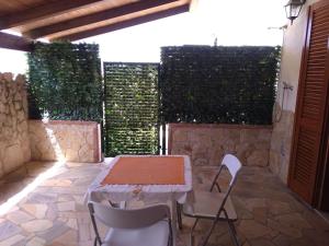einen Tisch und Stühle auf einer Terrasse mit einer Steinmauer in der Unterkunft Open Space da Luca e Laura,a 7 minuti da Alghero. in Olmedo