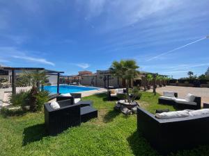 a resort yard with couches and a swimming pool at Chambres du Gozzi in Afa