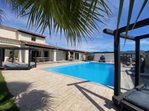 a swimming pool in front of a house at Chambres du Gozzi in Afa +45 photos