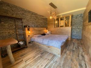 a bedroom with a bed and a wooden floor at Chambres du Gozzi in Afa