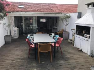 a table and chairs on a patio with a table and chairs at MAMALO in Biscarrosse