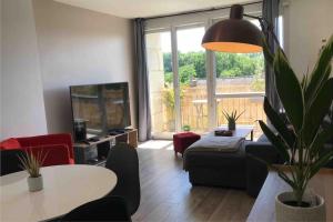 a living room with a couch and a table and a tv at Appartement - 45m2 avec parking in Avon