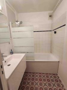 a white bathroom with a tub and a sink at Appartement - 45m2 avec parking in Avon