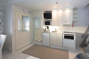 a white kitchen with white cabinets and a sink at Moonlight 402 Levi in Sirkka