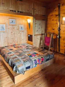 a bed in a room with a wooden wall at Très beau chalet familial - Vue superbe ! Plein sud in La Clusaz