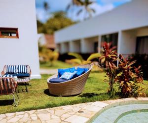 un patio con una silla y una bañera junto a una piscina en Mar Turquesa Eco Pousada, en Maragogi