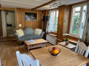 uma sala de estar com uma mesa e um sofá em Apartment Deer em Grindelwald