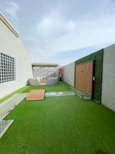 um quarto com relva verde e um edifício em الريف بلس em Hajlah