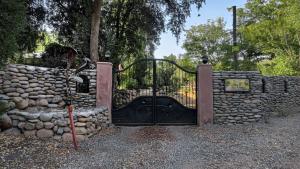 a gate in a stone wall with a stone at Tumuñan Lodge in El Llano