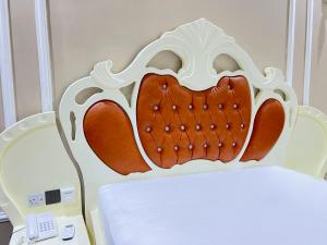 a headboard of a bed next to a telephone at East Africa Hotel by Mona Lisa in Morogoro