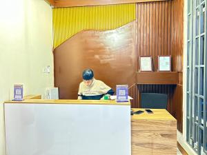 a man sitting at a counter in a office at East Africa Hotel by Mona Lisa in Morogoro