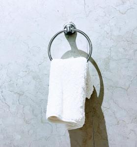 a towel hanging on a towel rack on a wall at East Africa Hotel by Mona Lisa in Morogoro