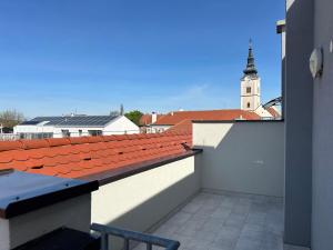 een balkon met uitzicht op een gebouw met een klokkentoren bij Apartman “Manhattan” in Križevci