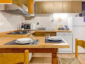 una cucina con tavolo in legno e frigorifero bianco di CASA BIVO by Design Studio a Pontelongo