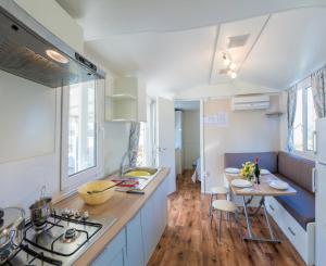 uma cozinha com um fogão e uma mesa com cadeiras em EUROCAMPINGPACENGO em Pacengo di Lazise